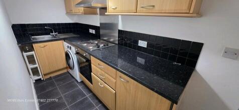 Modern kitchen with sleek dark worktops...
