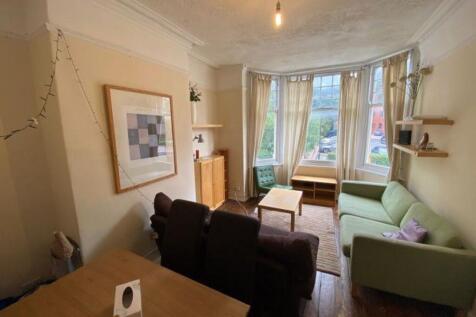 A bright and welcoming living room with large b...