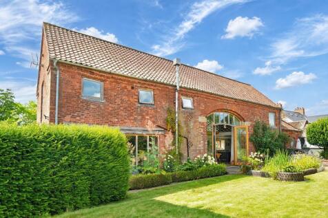 Timeless red brick architecture framed by mature planting