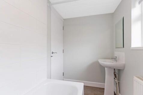 Bright, modern bathroom with a white bath, pede...