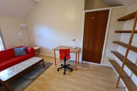Bright, tidy living area with a red sofa, coffe...