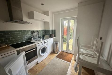 Bright kitchen with modern tiling and garden do...