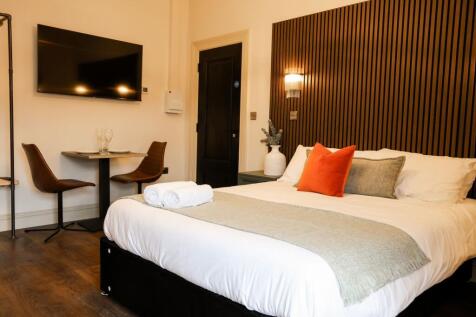 Sleek bedroom with feature wall and dining area...