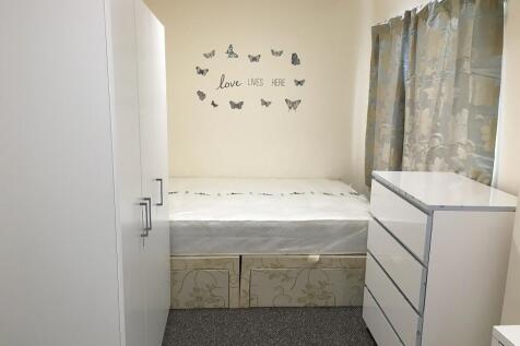 A bright and tidy single bedroom featuring a co...