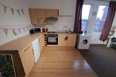 A bright and tidy kitchen featuring wooden cabi...
