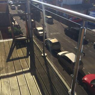 Sunny private balcony with modern glass-and-ste...