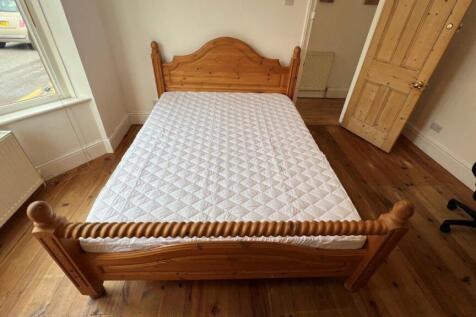 Bright bedroom with classic wood bed and floori...