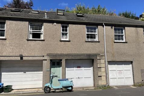 Row of garages with vintage scooter and clear s...