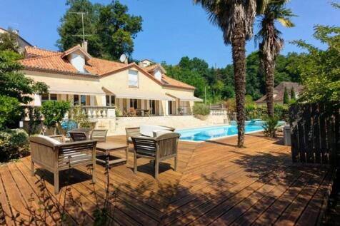 Une belle maison avec une terrasse en bois, des pa