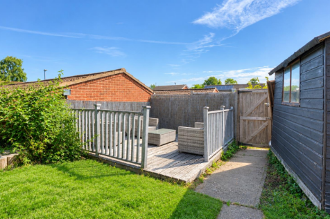 Sunny Garden Deck with Shed and Lush Lawn.png