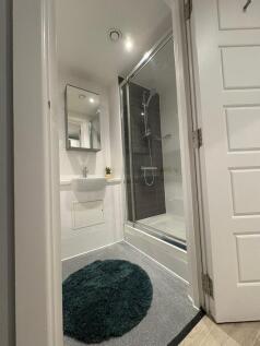 Bright modern bathroom with a glass-enclosed sh...
