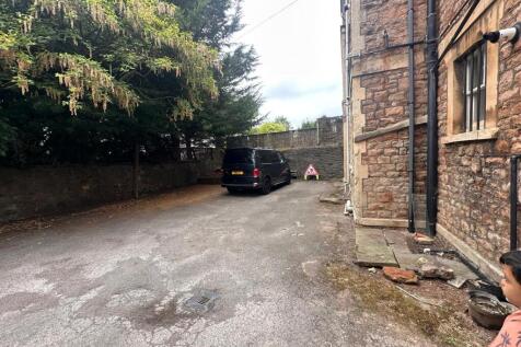 Private parking area beside a stone-built prope...