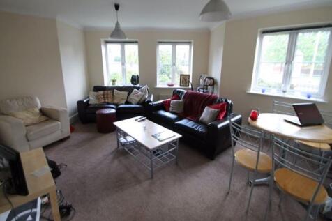 A spacious and well-lit living room featuring a...