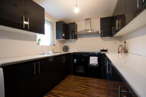 Modern kitchen with sleek dark cabinets and cou...