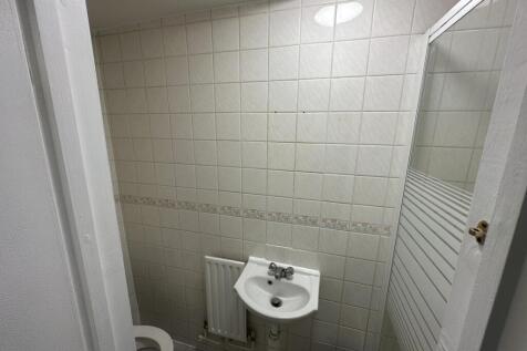 Compact bathroom with sink and tiled walls...