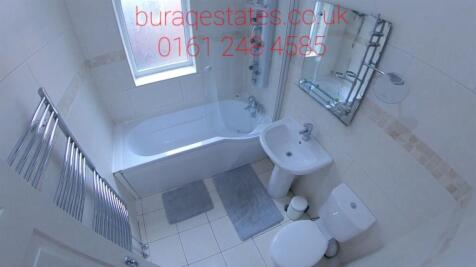 Bright and clean bathroom suite featuring a cur...