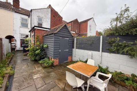 Private paved rear courtyard with a timber stor...