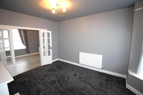 Bright lounge with bay window and neutral decor...