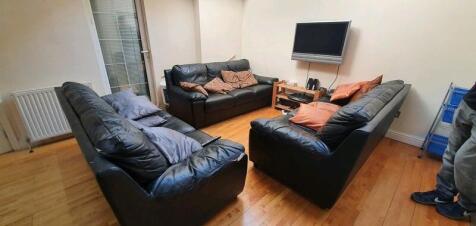 Bright lounge with three sofas and wall TV...