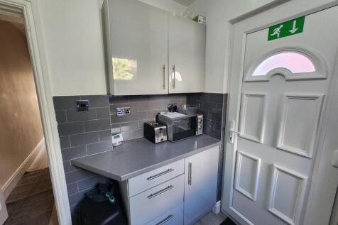 Compact, modern kitchenette with grey cabinetry...