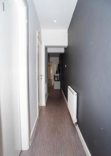 A clean, modern hallway with a dark feature wal...