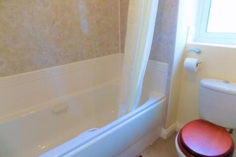 A bright and clean bathroom suite featuring a l...