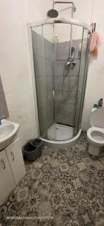 Compact, modern bathroom with a curved glass sh...
