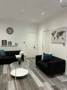 A modern, well-lit living room featuring two bl...