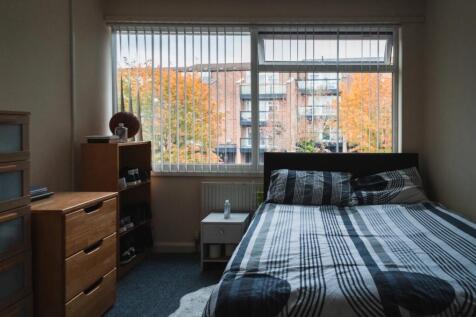 A cozy double bedroom featuring a large window ...