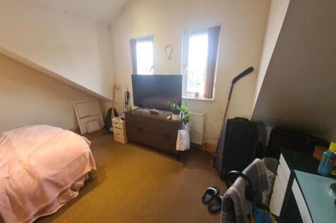 A cozy bedroom featuring a single bed and a sma...