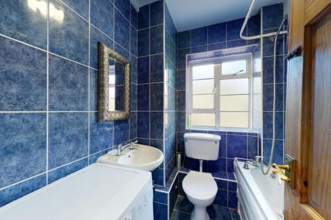 Bright bathroom with stylish blue tiling and ba...