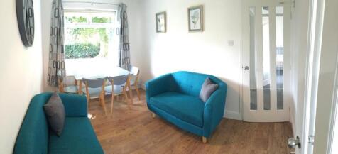 Bright, neatly furnished living room with match...