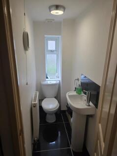 Neat, modern downstairs WC with glossy black ti...
