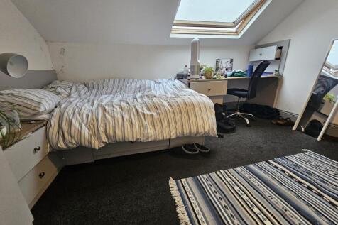 A bright, well-maintained bedroom with a single...