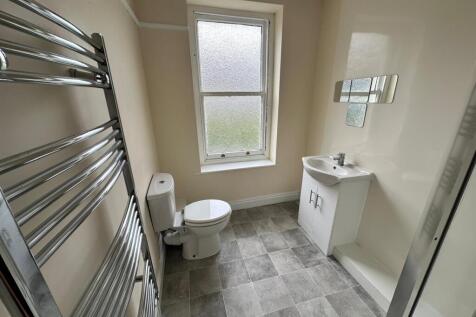 Bright, freshly painted bathroom with a frosted...