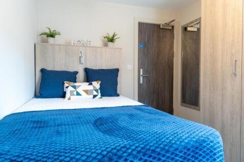 Bright, tidy bedroom with bold blue bedding...