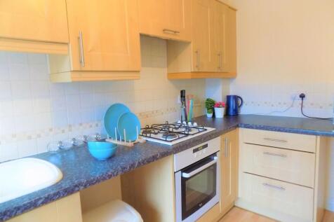 Bright and tidy kitchen featuring modern wooden...