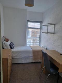 Bright bedroom with desk and ample storage spac...