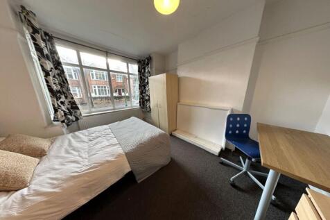A cozy single bedroom with a large window provi...