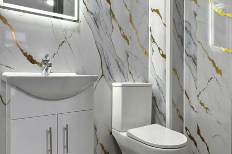 Bright modern bathroom with marble-effect wall ...