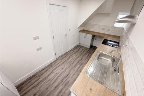 Modern kitchen with sleek wood-effect surfaces...