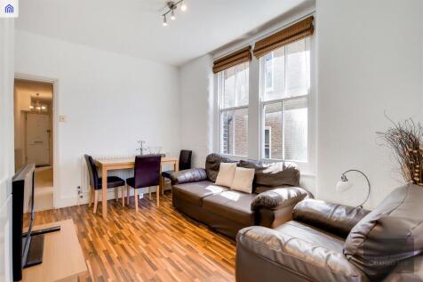 A bright two-bedroom Victorian first-floor flat on Queenstown Road, SW8. Features an open-plan kitchen/living area, private balcony, master bedroom, second double bedroom, and separate study. Excellen