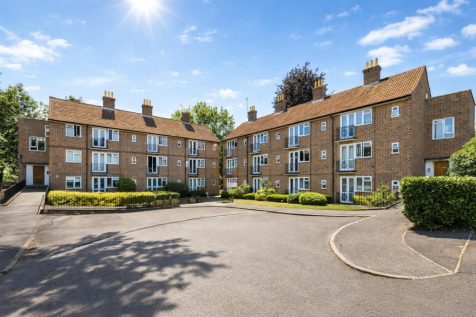 Sunny courtyard with red brick apartments.png