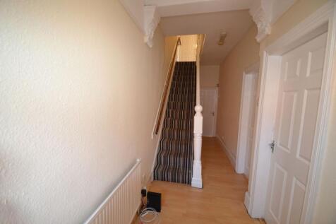 Bright, neutral hallway with wooden flooring, d...