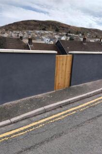 Modern garden wall with fresh wooden gate....
