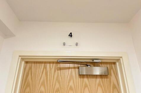 Clean communal door with clear number signage...