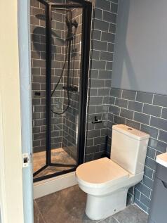 Stylish modern shower room with chic grey tilin...