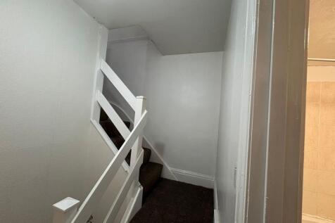 Compact painted staircase with carpeted steps...