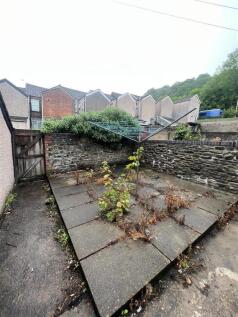 Private paved outdoor area with stone walls...
