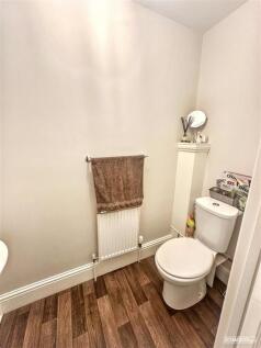 Clean downstairs cloakroom with wood flooring...